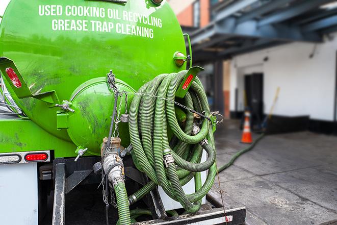 a professional technician pumping a restaurant's grease trap in Cary, IL